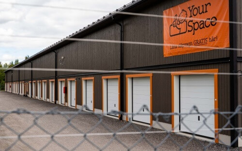 Garagelänga med elstängsel i förgrunden