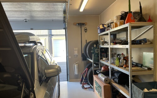 Garageinteriör med bokylla, bil och grejer